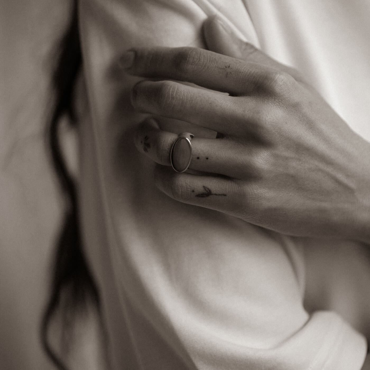 Close-up of a hand with a ring on a blurred background