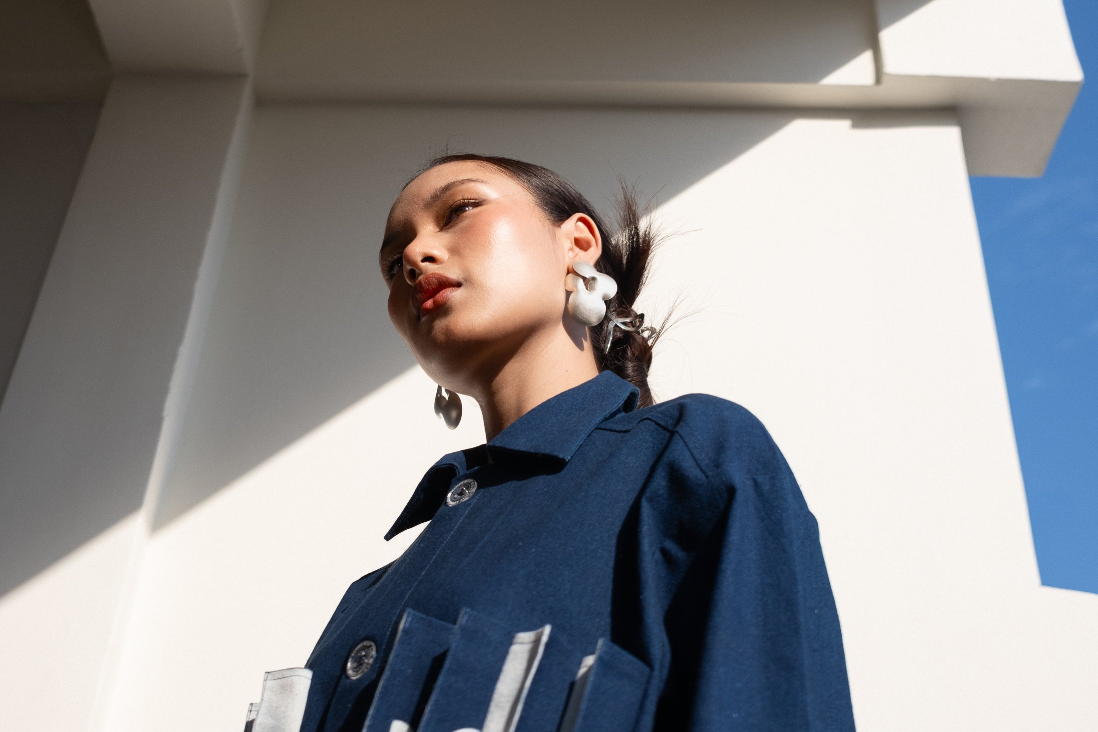 Woman wearing a blue jacket with a modern architectural background