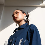 Woman wearing a blue jacket with a modern architectural background