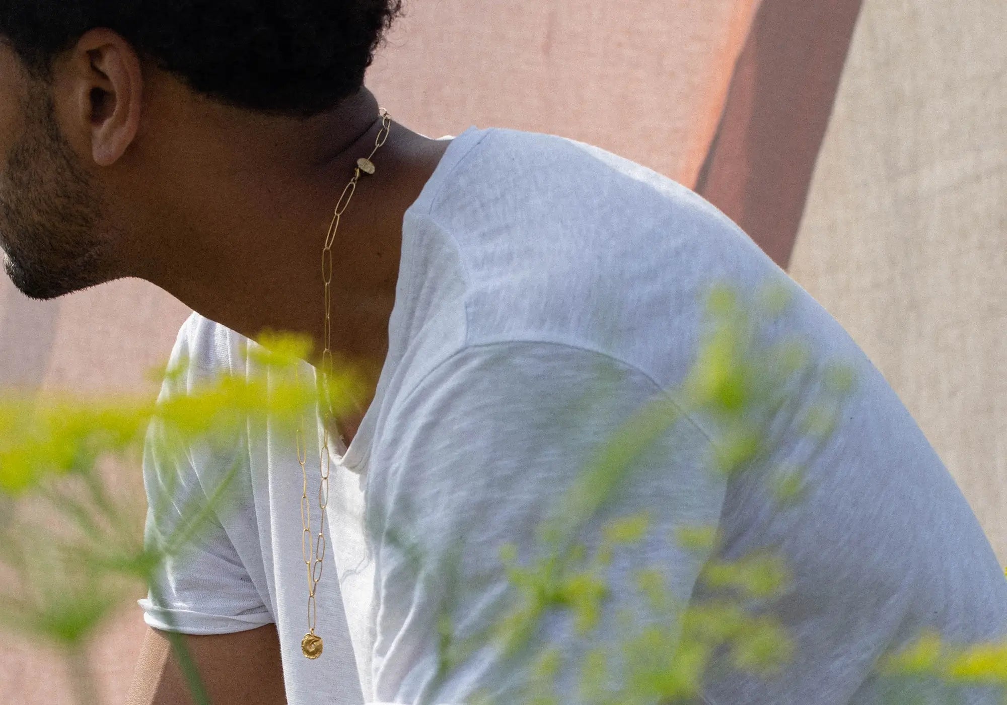 Man wearing a gold necklace with a blurred background